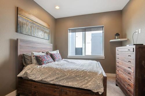 a bedroom with a bed with a dresser and a window at 2 BDR Home Roof Deck plus Walk to Broncos and Sloans Lake in Denver
