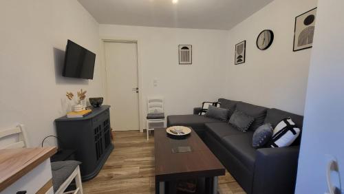 - un salon avec un canapé et une table dans l'établissement Houlia home διαμέρισμα με δωρεάν χώρο στάθμευσης, à Andros