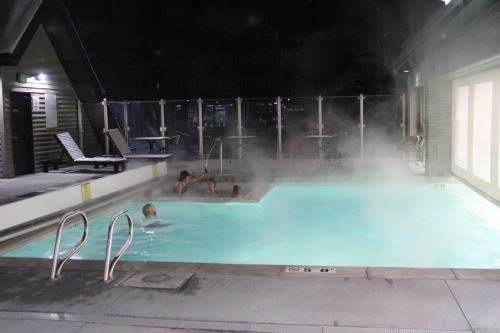 a group of people in a swimming pool at night at Breathtaking Mountain Views Ski In Out 2BR Condo in Park City