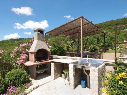 a outdoor kitchen with a pizza oven in a garden at Ferienhaus mit Privatpool für 6 Personen ca 85 qm in Rabac, Istrien Bucht von Rabac in Rabac