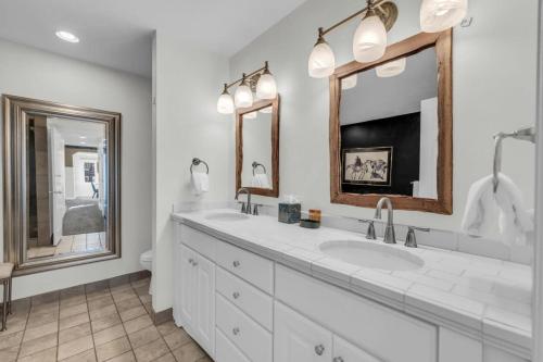a white bathroom with two sinks and two mirrors at Roomy 4BR Townhome Near Main St with Private Hot Tub in Park City