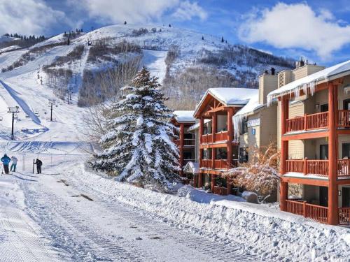 a ski lodge with a christmas tree in the snow at Ski in out 2BDR Condo with Shared Hot Tub and Views in Park City