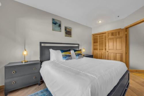 a bedroom with a large white bed and a wooden door at Steps From Ski Lift Garage Parking Included in Park City