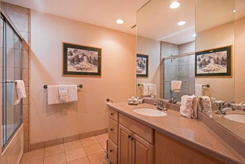 La salle de bains est pourvue de 2 lavabos et d'un grand miroir. dans l'établissement Ski in out 2 BDR Condo in the Heart of the Action, à Park City
