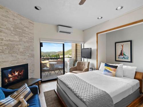 um quarto com uma cama king-size e uma lareira em Cozy Ski In Ski Out Studio with Hot Tub Access em Park City