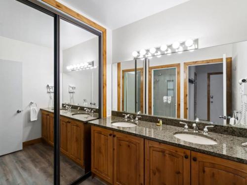 a bathroom with two sinks and two mirrors at Cozy Ski In Ski Out Studio with Hot Tub Access in Park City