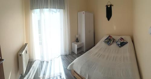 sypialnia z łóżkiem i dużym oknem w obiekcie Zacisze, domek na wsi blisko Trójmiasta w mieście Wiślinka