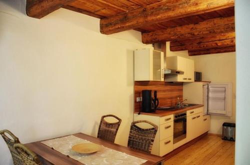 eine kleine Küche mit einem Tisch und Stühlen in einem Zimmer in der Unterkunft Ferienwohnung für 3 Personen ca 55 m in Görlitz, Lausitz Lausitzer Seenland in Görlitz