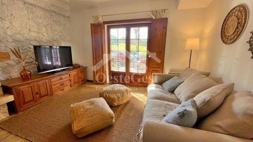 ein Wohnzimmer mit Sofa und Fernseher in der Unterkunft Ferienwohnung für 6 Personen ca 30 m in Lourinha, Regio Centro in Lourinhã