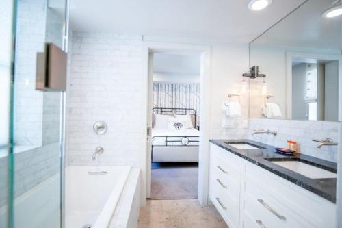 a white bathroom with a sink and a tub at Amazing 3BR Condo on Main with Hot Tub Steps to Lift in Park City