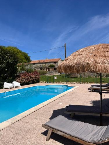 - une piscine avec un parasol et 2 chaises longues dans l'établissement Le Plantier2, à Beaulieu-sur-Sonnette