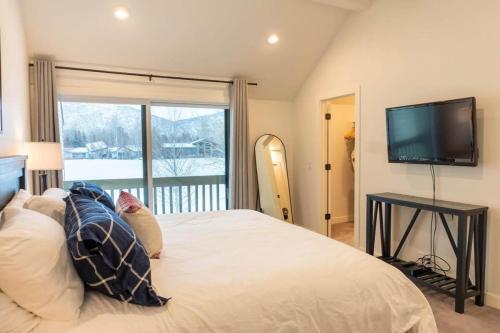 a bedroom with a large bed with a flat screen tv at Modern 3BR in Serene Area Near Ski Slopes and Town in Park City