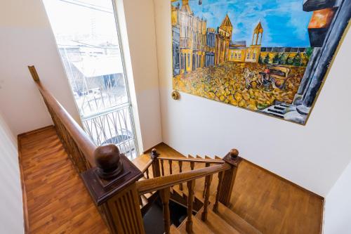 a staircase with a painting on the wall next to a window at YAN HOTEL in Yerevan