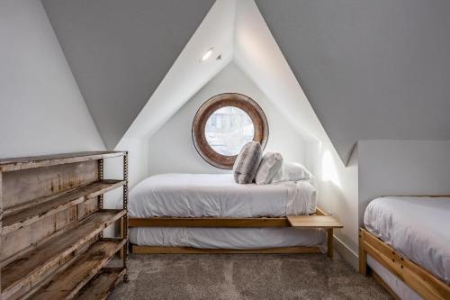 a attic bedroom with two beds and a window at Intimate 2BDR in Heart of Town Walk to Ski Lift in Park City