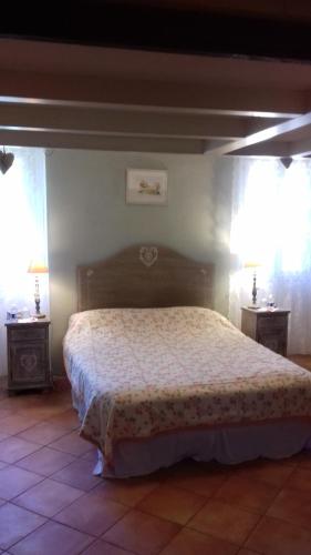 a bedroom with a bed and two night stands at B&B L'Avelan in La Trinité