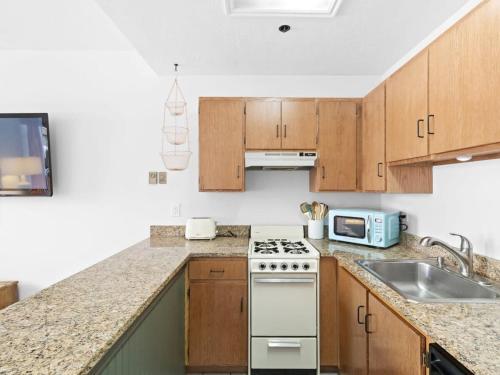 a kitchen with wooden cabinets and a white stove top oven at One BDR In Heart of Park City in Park City