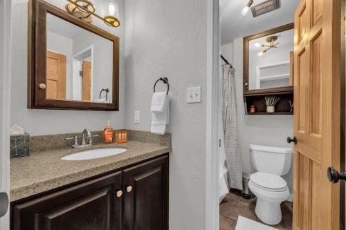 a bathroom with a sink and a toilet and a mirror at City Center 2BDR, Ski In - Close to Lift in Park City