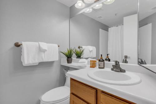 a bathroom with a sink and a toilet and a mirror at 2BR Condo Near Trails and Ski Resorts in Park City