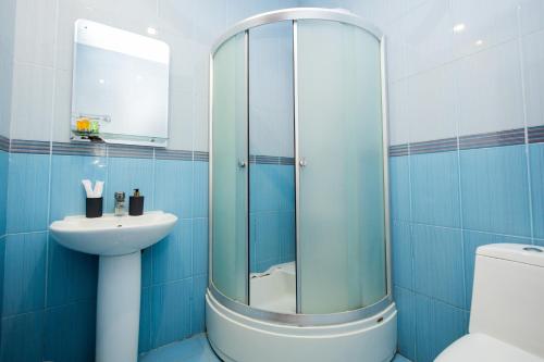 a blue bathroom with a shower and a sink at YAN HOTEL in Yerevan