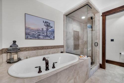 La salle de bains est pourvue d'une grande baignoire et d'une douche en verre. dans l'établissement Ski-in Ski-out 2BR at Deer Valley, à Park City