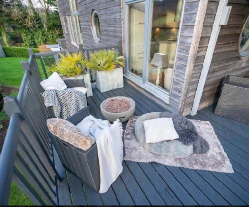 a deck with two chairs and a table at Luxurious villa south Dublin in Dublin