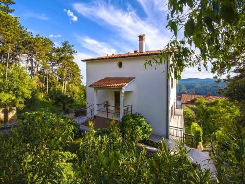 ein kleines weißes Haus mit einem Balkon und Bäumen in der Unterkunft Studio für 4 Personen ca 40 qm in Rabac, Istrien Bucht von Rabac in Rabac