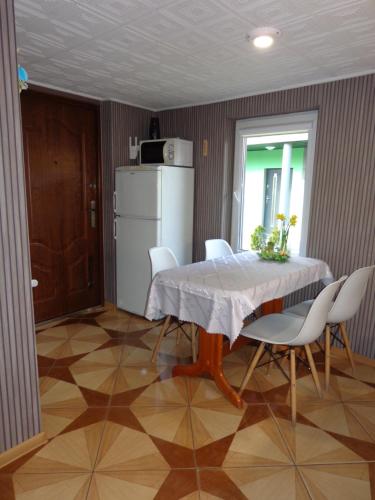 a kitchen with a table and chairs and a refrigerator at Noclegi Skałka in Olsztyn