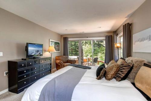 een slaapkamer met een groot bed en een televisie. bij Ski in and out 4BDR Townhome with Aspen Views and Hot Tub in Park City