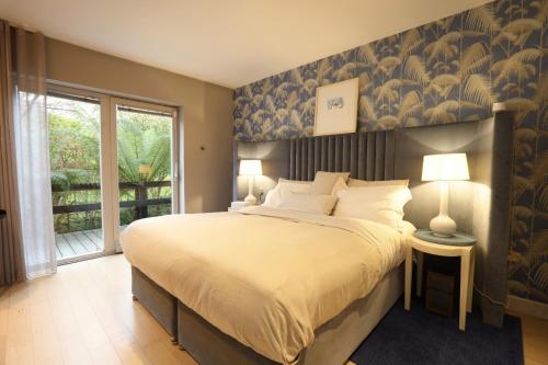 - une chambre avec un grand lit et une grande fenêtre dans l'établissement Luxurious villa south Dublin, à Dublin