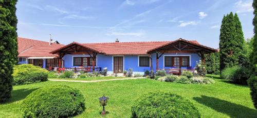 une maison bleue avec une cour verdoyante dans l'établissement Ferienwohnung für 2 Personen 1 Kind ca 35 qm in Zalakaros, Westungarn Zala - b56517, à Zalakaros