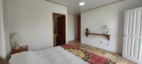 ein Schlafzimmer mit einem weißen Bett und einem Fenster in der Unterkunft VILLA FLOREANA in Puerto Velasco Ibarra