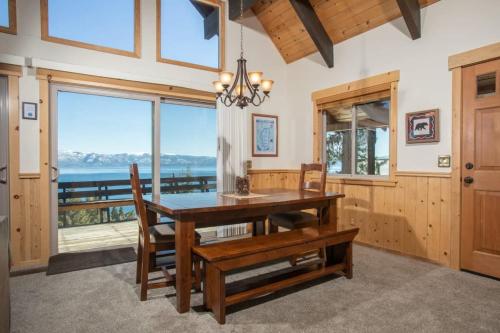 een eetkamer met een tafel en stoelen en een groot raam bij Carnelian Bay View Cabin in Carnelian Bay