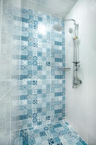 a bathroom with a shower with blue and white tiles at Moss Art Boutique Hotel in Baku