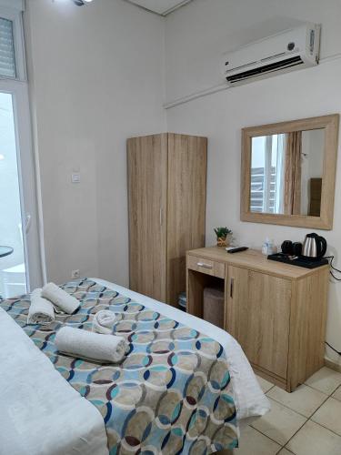 a bedroom with a bed and a desk and a mirror at Pelineon Rooms in Chios