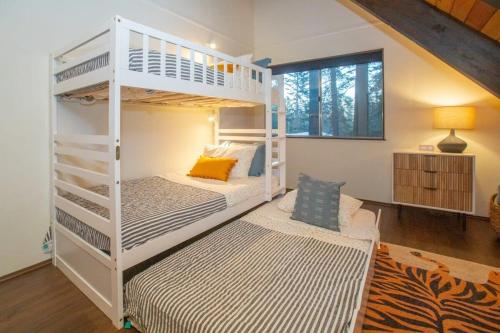 two white bunk beds in a room with a desk at Chalet Blue Modern 4BD Tahoe Home in Tahoe City