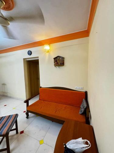 une chambre avec un banc et une table. dans l'établissement F2 apartments, à Mumbai
