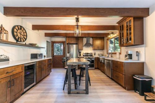 a large kitchen with wooden cabinets and a island at Brand New 3BDR Cabin 4 Min to Ski Resort and Beach in Tahoma
