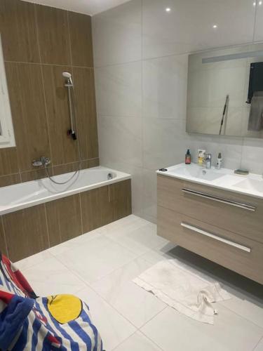 une salle de bain avec une baignoire, un lavabo et un miroir dans l'établissement Villa 3 chambres avec piscine, à Avignon