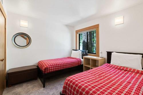 a hotel room with two beds and a mirror at Bright 2BDR Next to NorthStar - 5min Walk! in Truckee