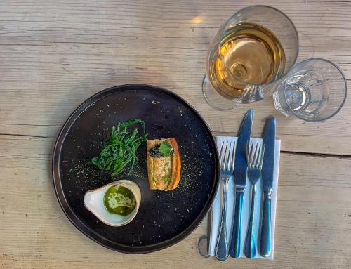 a black plate with a egg and vegetables on a table at The Dabbling Duck in Great Massingham