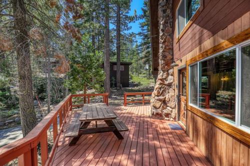 a wooden deck with a picnic table on a house at Brand New 3BDR Cabin 4 Min to Ski Resort and Beach in Tahoma