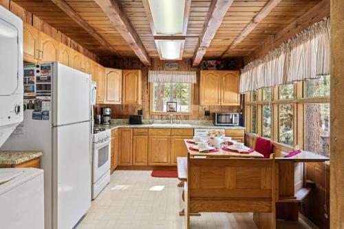 a kitchen with wooden cabinets and a white refrigerator at 3BR Mountain Cabin-Near Beach & Slopes in Homewood