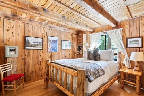 a bedroom with a bed in a room with wooden walls at 3BR Mountain Cabin-Near Beach & Slopes in Homewood