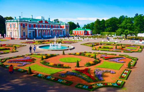 a large building with a fountain and a garden at Spacious Apartment in Kadriorg, Tallinn City Centre in Tallinn