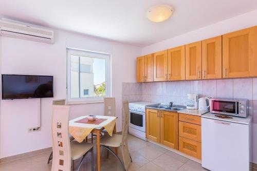 eine Küche mit Holzschränken und einem kleinen Tisch in der Unterkunft Ferienwohnung für 4 Personen ca 40 m in Medulin, Istrien Südküste von Istrien - b55580 in Medulin