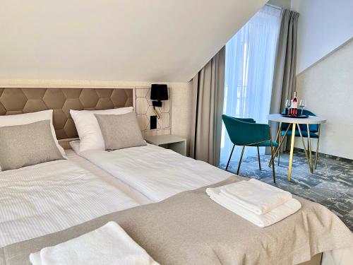 a bedroom with two beds and a table and a chair at SILVER BALTIC in Kołobrzeg