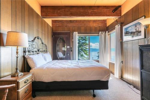 - une chambre avec un lit et une grande fenêtre dans l'établissement 3BD Home with Panoramic Lake Tahoe Views, à Carnelian Bay