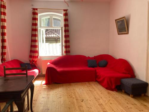 - un canapé rouge dans une chambre avec fenêtre dans l'établissement Vila Flavia, à Sinaia