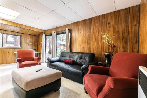 a living room with a black leather couch and two chairs at Agate Bay 3BDR, Walking Distance to the Beach! in Tahoe Vista