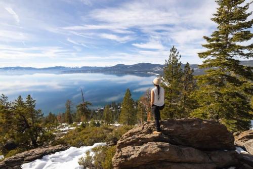 a person standing on top of a rock looking at the water at Agate Bay 3BDR, Walking Distance to the Beach! in Tahoe Vista